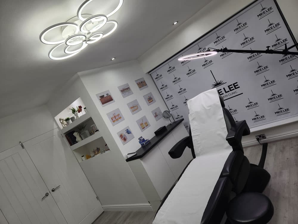Treatment room with a couch and the clinic logo backdrop